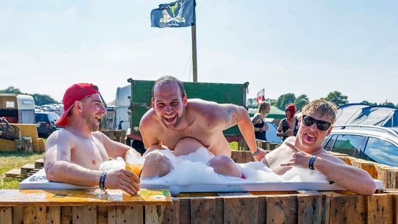 30. Juli 2019: Diese Besucher des Heavy Metal-Festivals im schleswig-holsteinischen Wacken kühlen sich im selbstgebauten Pool ab. © picture alliance / Geisler-Fotopress Foto: Andre Havergo/Geisler-Fotopress