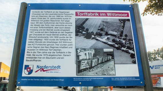 Eine Infotafel vor einem Baumarkt-Parkplatz weist auf die Geschichte des Grundstücks und das KZ Wittmoor hin.  Foto: Marc-Oliver Rehrmann