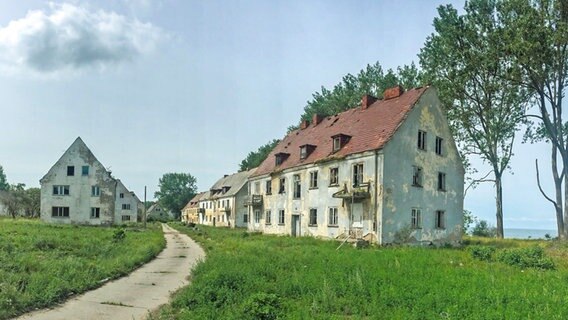Verfallende Häuser auf der Halbinsel Wustrow, dahinter der Ostseestrand. © NDR Foto: Daniel Sprenger