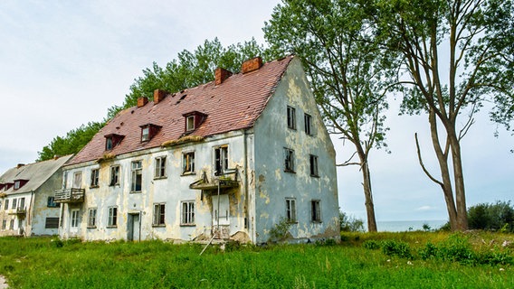 Verfallende Häuser auf der Halbinsel Wustrow, dahinter die Ostsee. © NDR Foto: Daniel Sprenger