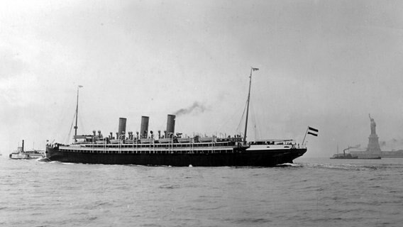 Historische Aufnahme des Dampfschiffs "Augusta Victoria" der Reederei Hapag vor New York mit der Freiheitsstatue.  