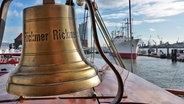 Blick auf die Schiffsglocke der Rickmer Rickmers mit der Cap San Diego im Hintergrund © NDR Foto: Irene Altenmüller