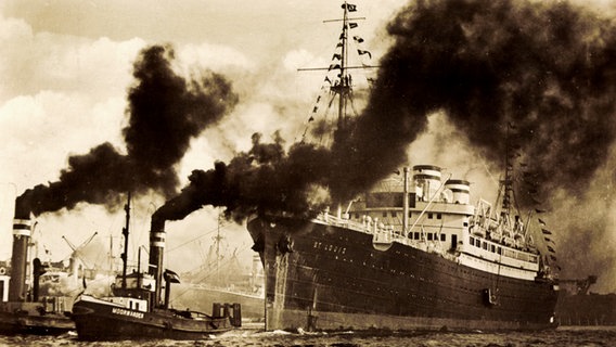 Das Dampfschiff "MS St. Louis" wird von zwei Schleppern aus einem Hafen gezogen (um 1934). © picture alliance / arkivi 