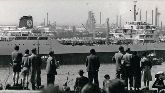 Zuschauer beobachten 1960 die Ausfahrt des damals größten Tankers der Welt, der "Al-Malik Saud Al-Awal" in Hamburg. © imago/ZUMA Press 