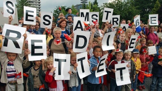 Rund 100 Kinder, Eltern und Großeltern protestieren am 1. Juli 2003 vor dem NDR-Standort Hamburg-Lokstedt für die Beibehaltung der "Sesamstraße"-Sendezeit. © picture-alliance / dpa/dpaweb Foto: Kay Nietfeld