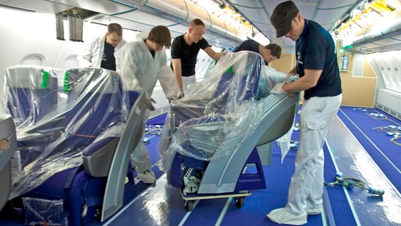 Männer montieren Sitze in ein Flugzeug des Typs Airbus A380. © Airbus 