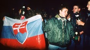 Junge Menschen mit der slowakischen Flagge feiern am 31. Dezember 1992 in der Hauptstadt Bratislava die Staatsgründung der Slowakei. Zum Jahreswechsel 1992/93 hörte die CSFR auf zu existieren. Zwei neue Staaten, die Tschechische und die Slowakische Republik, gingen aus ihr hervor. © picture alliance / CTK / dpa 