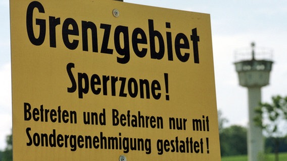 Warnschild an der DDR-Sperrzone mit Kontrollturm im Hintergrund © ZB - Fotoreport Foto: Jan-Peter Kasper