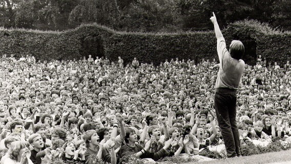 Herbert Grönemeyer reckt bei einem Auftritt im Hamburger Stadtpark 1986 vor Tausenden Fans den Arm nach oben. © Karsten Jahnke Konzertdirektion 