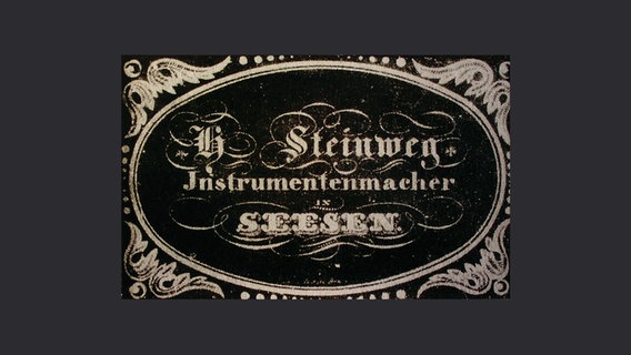 Ein Firmenschildaufkleber mit der Aufschrift "H. Steinweg, Instrumentenmacher, Seesen". © Städtisches Museum Seesen / Stadtarchiv Seesen 