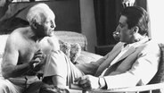 Regisseur Lee Strasberg erklärt mit nackten Oberkörper seinem Hauptdarsteller Al Pacino während der Dreharbeiten seines Films "The Godfather Part II" , wie er sich eine bestimmte Szene vorstellt. Aufnahme vom Dezember 1974. © picture-alliance / dpa | UPI 