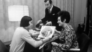 Ein Tanzlehrer der DDR-Tanzschule Seiffert wählt 1972 mit einem Schüler Schallplatten aus. © picture alliance / akg-images | akg-images / Gardi 