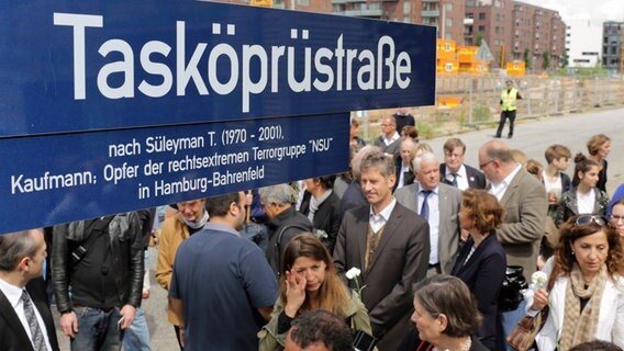 Besucher des Festakts zur Umbenennung der Strasse "Kohlentwiete" in "Tasköprüstraße" stehen am 26. Juni 2014 in Hamburg um das Strassenschild der "Tasköprüstrasse". © picture alliance / dpa Foto: Axel Heimken