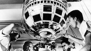 Amerikanische Ingenieure bereiten den neuen Kommunikationssatelliten "Telstar" am 7. Juli 1962 in Cape Canaveral, Florida, für den Start ins All vor. © picture alliance / UPI 