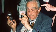 Der ungarisch-amerikanische Physiker Edward Teller hält am 27.  September 1994 im russischen Zentrum für Nuklearwaffen in Tscheljabinsk den Zünder der ersten sowjetischen Wasserstoffbombe in der Hand. © picture-alliance / dpa | epa Gubarew 