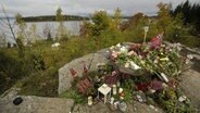 Blumen, Kerzen und Norwegen-Fahnen auf der Insel Utøya in Gedenken an die Opfer der Anschläge durch Anders Behring Breivik 2011. © picture alliance / dpa Foto: Antti Aimo-Koivisto