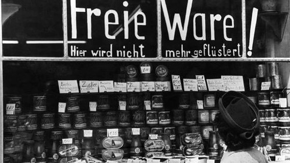 Ein Lebensmittelladen wirbt nach der Währungsreform 1948 mit dem Spruch 