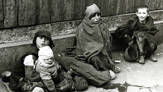 Ausgehungerte und frierende Kinder sitzen 1941 auf einer Straße im Warschauer Ghetto. © picture alliance / Mary Evans Picture Library 