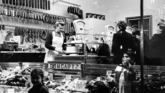 Verkäuferin und Kundinnen in einer Fleischerei, Aufnahme um 1951. © picture-alliance / akg-images / Erich Lessing Foto: Erich Lessing