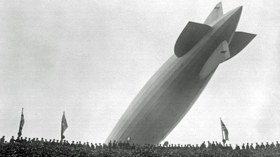 Ein Zeppelin fliegt 1930 über das voll besetzte Wembley-Stadion in London. © dpa - Sportreport 