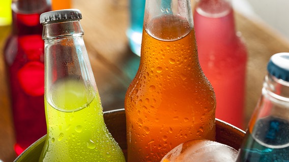 Farbige Getränke in Kronkorkenflaschen auf Eis in einem Kühler. © fotolia.com Foto: Brent Hofacker
