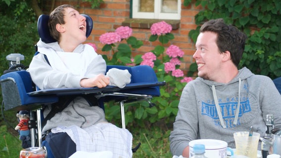 Ein Junge im Rollstuhl (links) und ein junger Mann. Beide leben im "Erlenbusch", einer Einrichtung für Menschen mit Behinderungen. © Martha Stiftung Foto: Martha Stiftung