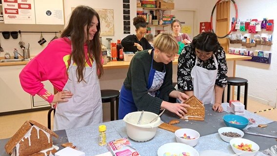 Die Teilnehmerinnen des Lebenshilfe Mädchentreffs in Hamburg basteln Lebkuchenhäuser © NDR Foto: Petra Volquardsen