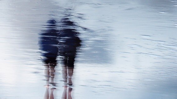 Reflexion im Wasser von Spaziergängern am Strand. © photocase.de Foto: Saimen