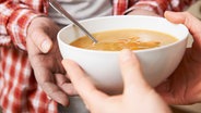 Eine Schüssel mit Suppe wird überreicht. © fotolia.com Foto: highwaystarz
