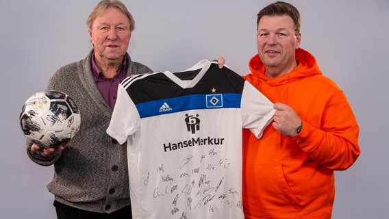 Horst und Danny Hrubesch halten ein signiertes HSV-Trikot in den Händen. © NDR Foto: Christoph Klipp