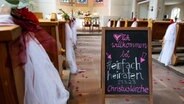 Ein Schild mit der Aufschrift "Herzlich willkommen bei "einfach heiraten" steht in einer Kirche. © picture alliance/dpa | Sven Hoppe Foto: Sven Hoppe