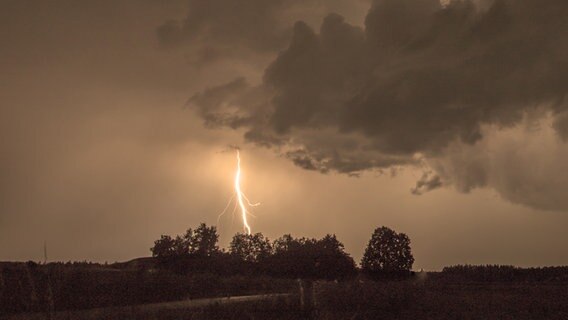 Ein Blitz schlägt in einer dunklen Landschaft ein. © photocase Foto: salvia77