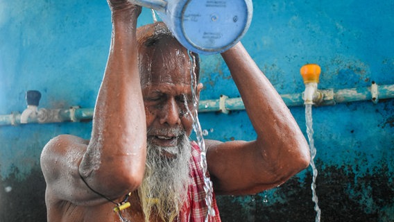 Ein Mann in Indien schüttet sich Wasser über den Kopf © picture alliance / NurPhoto Foto: Sudipta Das