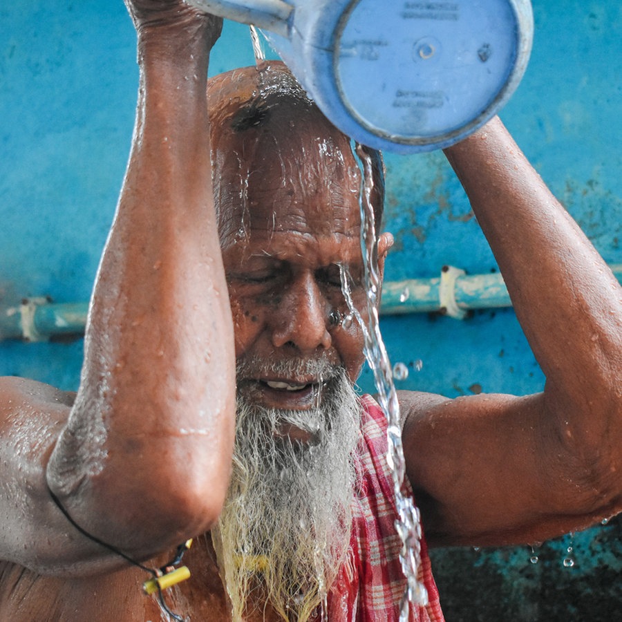 Ein Mann in Indien schüttet sich Wasser über den Kopf © picture alliance / NurPhoto Foto: Sudipta Das