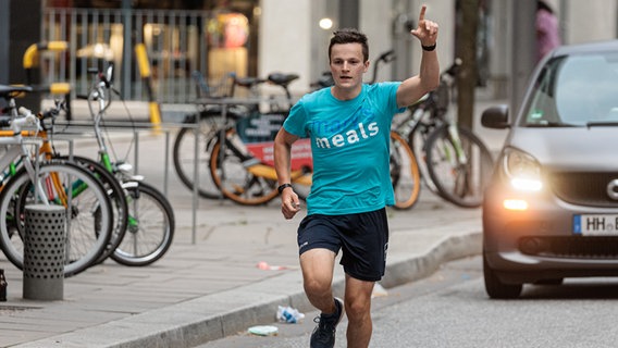 Der 16-jährige Schüler Denis Holub läuft nach seinem 1.100 Kilometer langen Spendenlauf von Freiburg nach Hamburg zum Zieleinlauf in der Hafencity. © picture alliance/dpa Foto: Markus Scholz