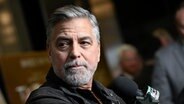 Der US-Schauspieler George Clooney schaut bei einerm Pressetermin zum Film "The Boys in the Boat" im Dezember 2023 an der Kamera vorbei © picture alliance Foto: Evan Agostini