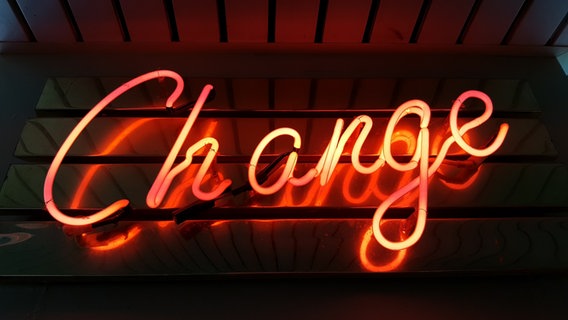 Ein Neon-Schriftzug zeigt das Wort "Change" © Ross Findon via unsplash Foto: Ross Findon via unsplash