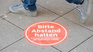 Eine Corona-Abstandsmarkierung auf dem Boden. © picture alliance Foto:  Julian Stratenschulte