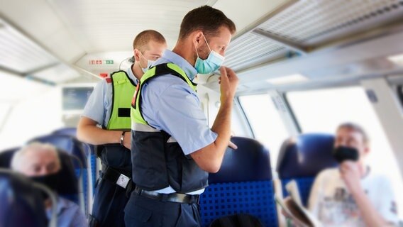 Mitarbeiter der DB Sicherheit und Beamte der Bundespolizei gehen durch einen Zug und kontrollieren, ob die Corona-bedingte Maskenpflicht eingehalten wird. © picture alliance/Annette Ried Foto: Annette Ried