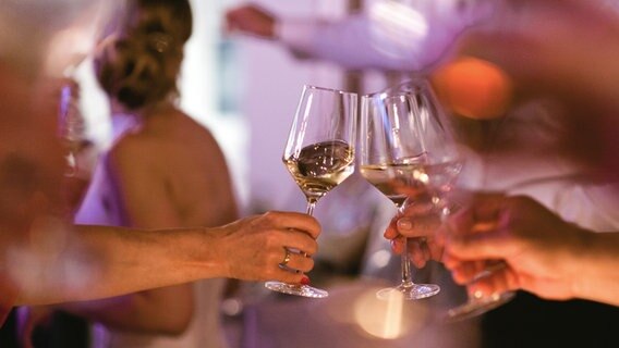 Es wird auf einer Party mit Weißwein angestoßen. © photocase Foto: vanda lay