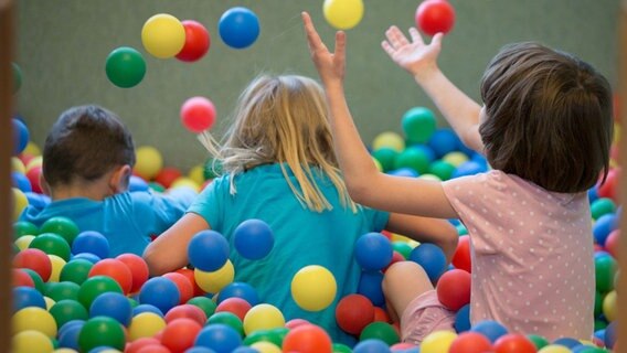 Kinder spielen in einem Bällebad. © dpa Foto: Friso Gentsch