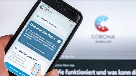 Corona warning app in front of the monitor with turquoise-red logo © imago-images Photo: Jan Huebner