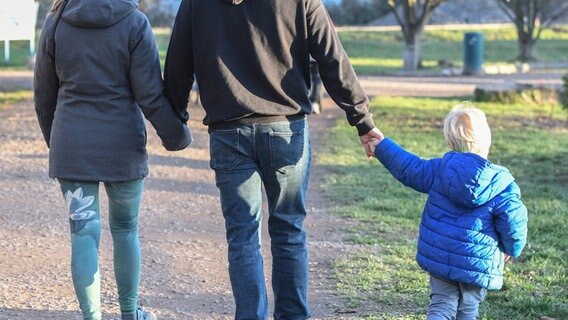 Eltern gehen mit Kind an der Hand spazieren. © Picture Alliance / Winfried Rothermel Foto: Winfried Rothermel