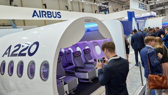 Besucher betrachten am Airbus-Stand die neuen Premium Economy und Economy-Class-Sitze auf der Aircraft Interiors Expo in den Messehallen Hamburg. © picture alliance / dpa Foto: Georg Wendt