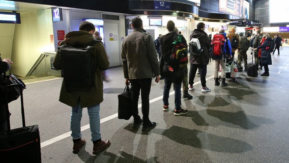 Reisende stehen Schlange im Hamburger Hauptbahnhof, um an einem Schalter der Deutschen Bahn Informationen zu bekommen. © dpa Foto: Bodo Marks