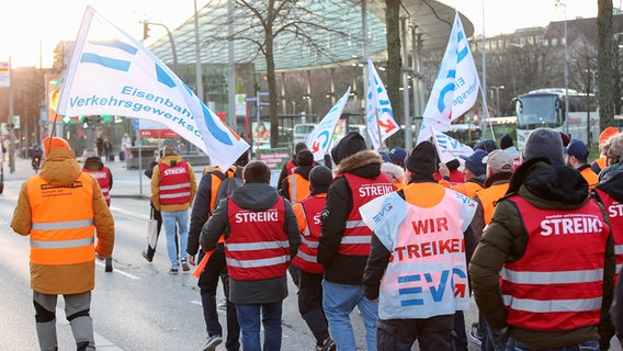 Streikende Mitglieder der EVG ziehen mit Fahnen und Streikwesten vom Hauptbahnhof zum Gewerkschaftshaus am Besenbinderhof. © picture alliance/dpa Foto: Bodo Marks