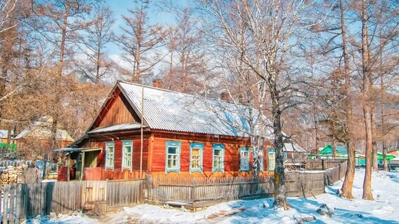 Malerisches Holzhaus im Wald an einem sonnigen Wintertag. © photocase Foto: Private Person