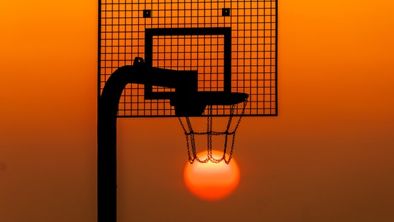 Die Sonne geht hinter einem Basketballkorb auf. © NDR Foto: Andy Bünning aus Torgelow