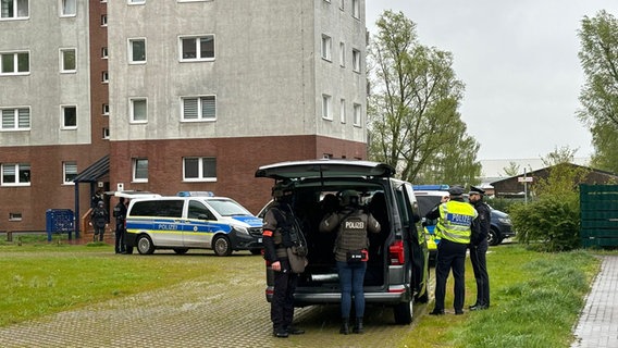 Polizei und SEK-Einsatzbeamte stehen vor einem Hochhaus in Rostock. © Stefan Tretropp Foto: Stefan Tretropp