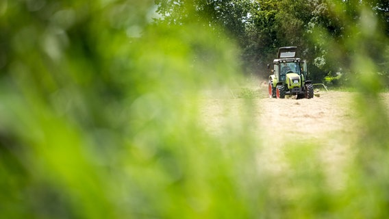 Ein Landwirt fährt mit einem Traktor über ein Feld. © dpa-Bildfunk Foto: Sina Schuldt/dpa